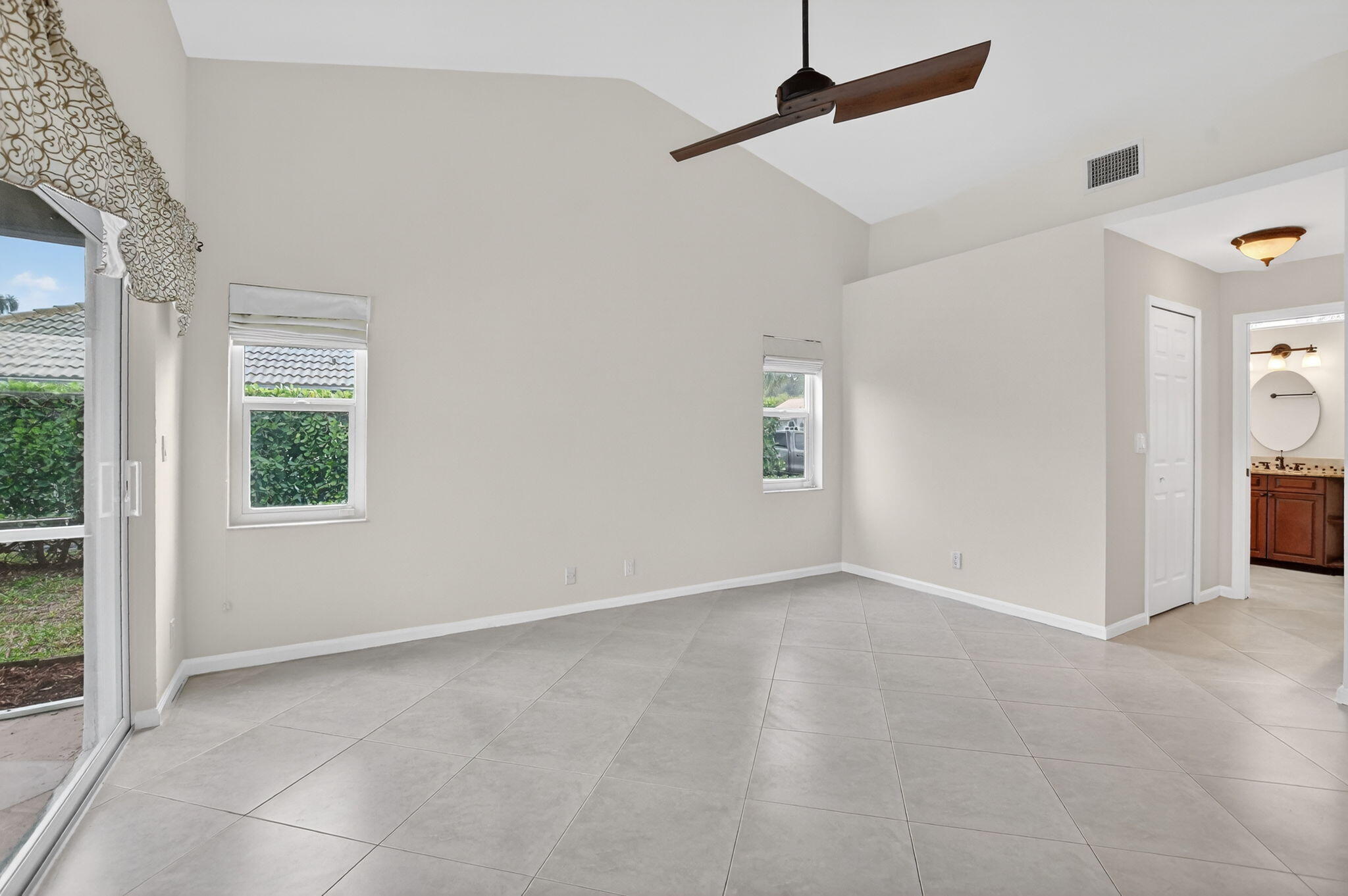 10194 Canoe Brook Circle Boca Raton, FL 33498 - Photo 12 of 42 an empty room with windows and ceiling fan