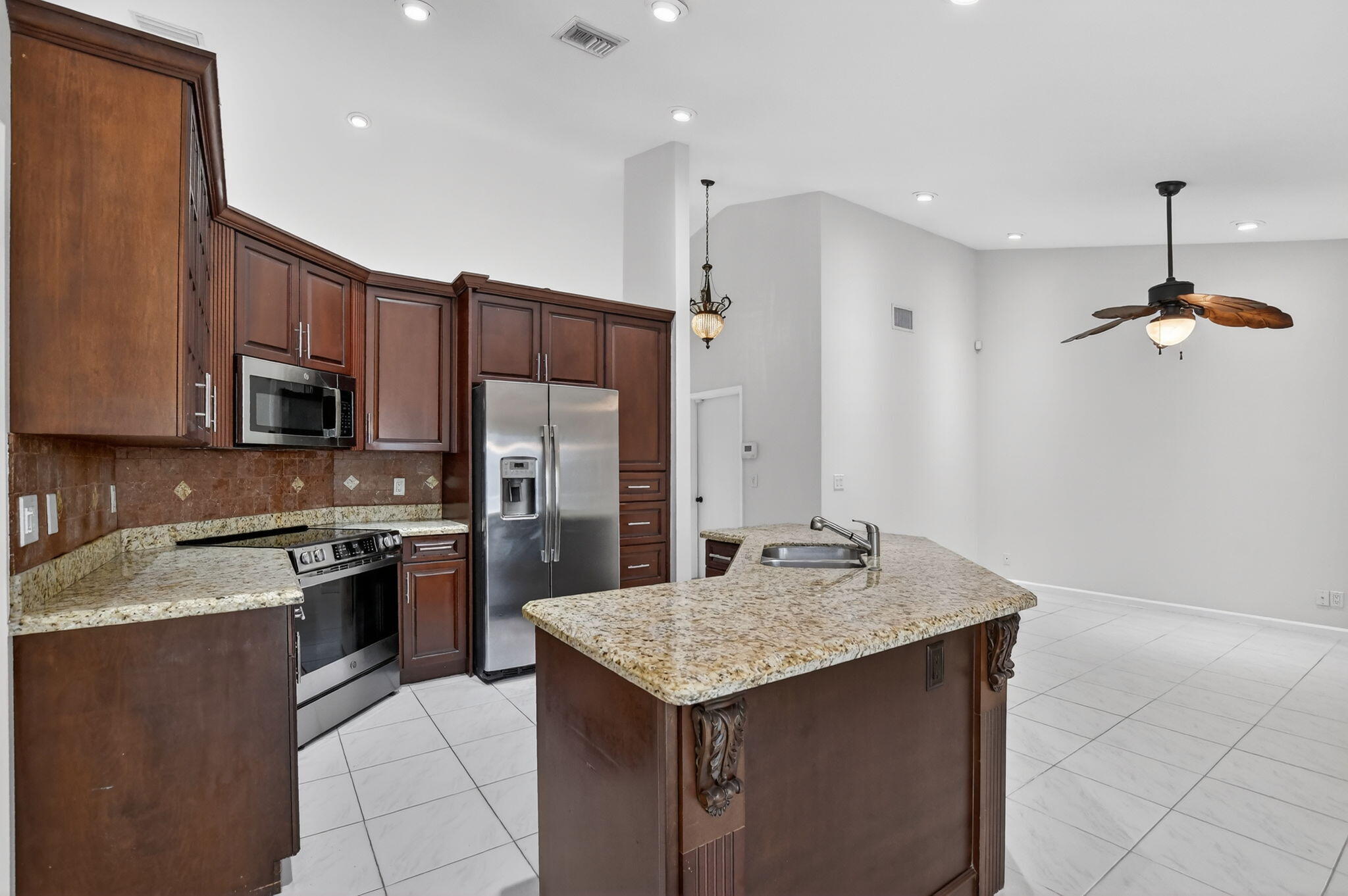 10194 Canoe Brook Circle Boca Raton, FL 33498 - Photo 19 of 42 a kitchen with kitchen island granite countertop stainless steel appliances cabinets a sink and a counter top space