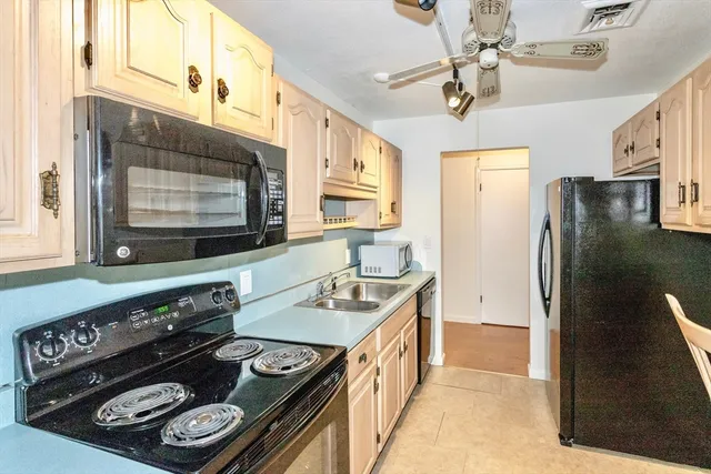 a kitchen with stainless steel appliances granite countertop a refrigerator a stove and a sink with wooden floor