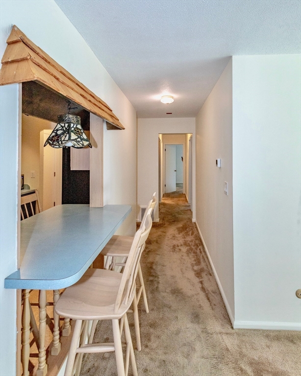 324 Russell Road, Unit 204 Westfield, MA 01085 - Photo 10 of 31 a view of a hallway with a dining table and chairs