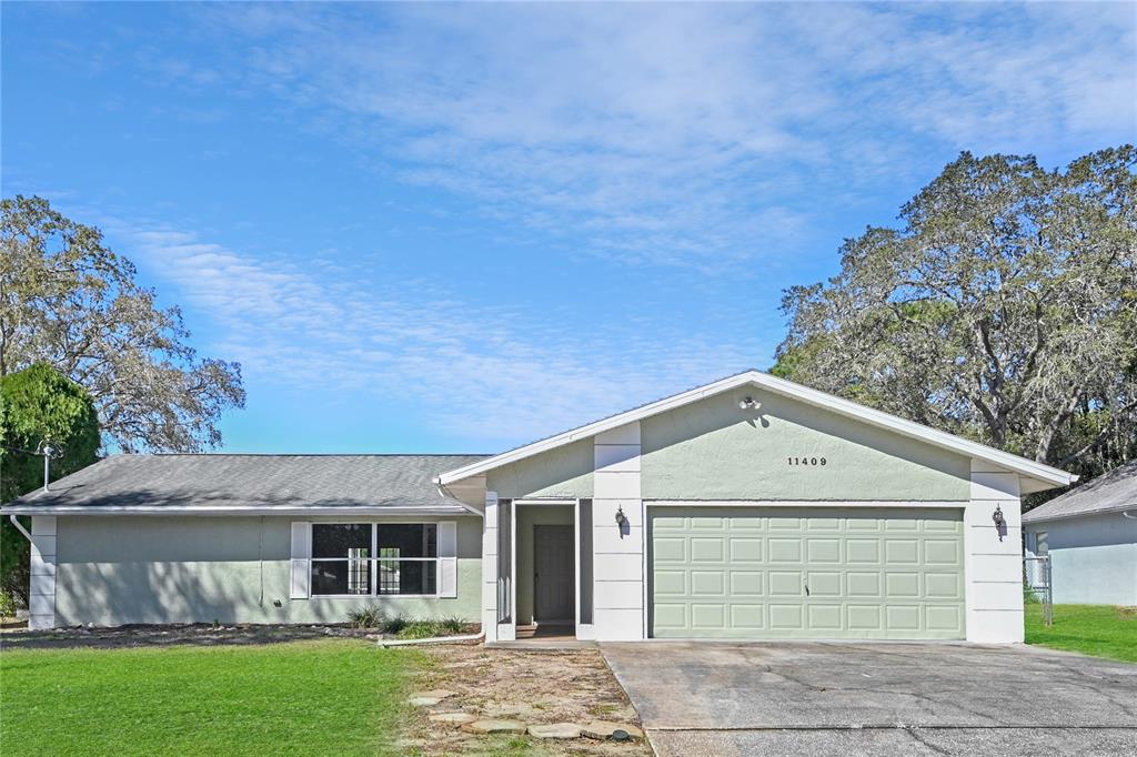 11409 Callaghan Avenue Spring Hill, FL 34608 - Photo 1 of 1 a front view of a house with a garden