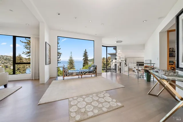 a living room with furniture large window and wooden floor