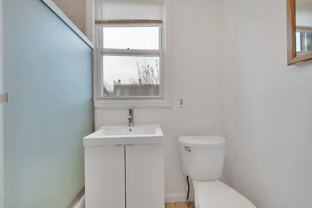 a bathroom with a toilet a sink and mirror