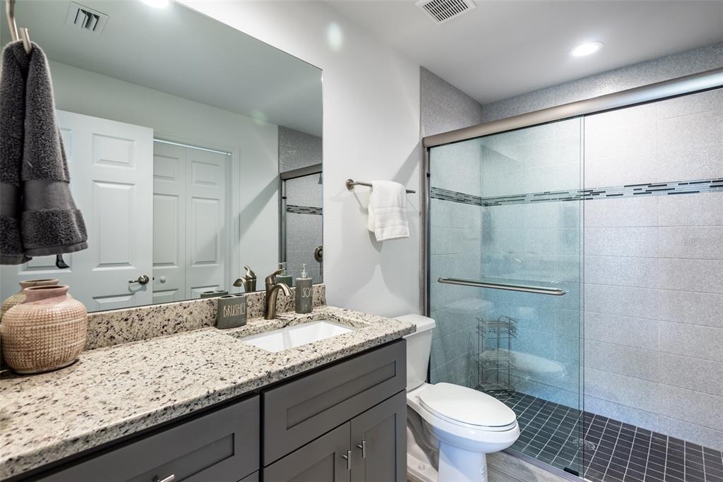 219 Lewis Circle, Unit 112 Punta Gorda, FL 33950 - Photo 28 of 36 a bathroom with a granite countertop sink mirror vanity and toilet