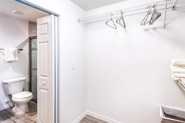 a bathroom with a granite countertop shower a toilet and a shower