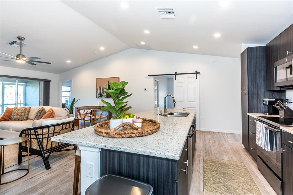 219 Lewis Circle, Unit 112 Punta Gorda, FL 33950 - Photo 5 of 36 a kitchen with granite countertop kitchen island stainless steel appliances a sink and counter space
