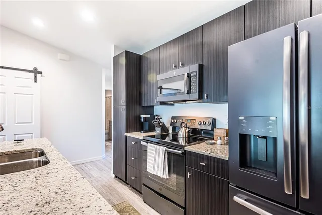 a kitchen with stainless steel appliances granite countertop a refrigerator and a stove