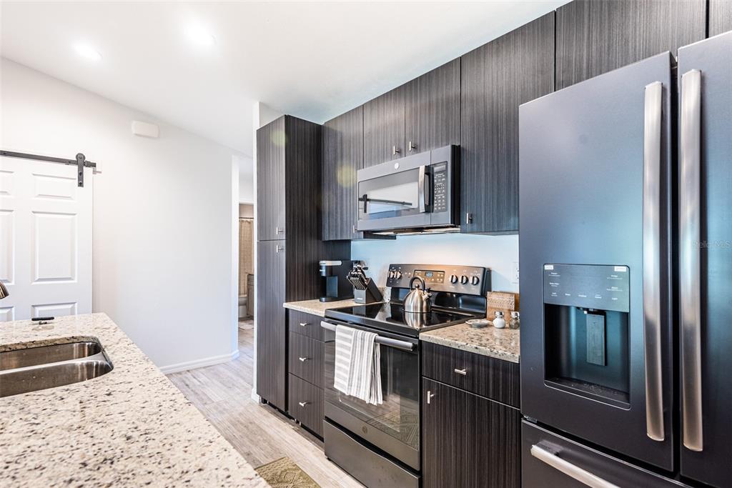 219 Lewis Circle, Unit 112 Punta Gorda, FL 33950 - Photo 6 of 36 a kitchen with stainless steel appliances granite countertop a refrigerator and a stove