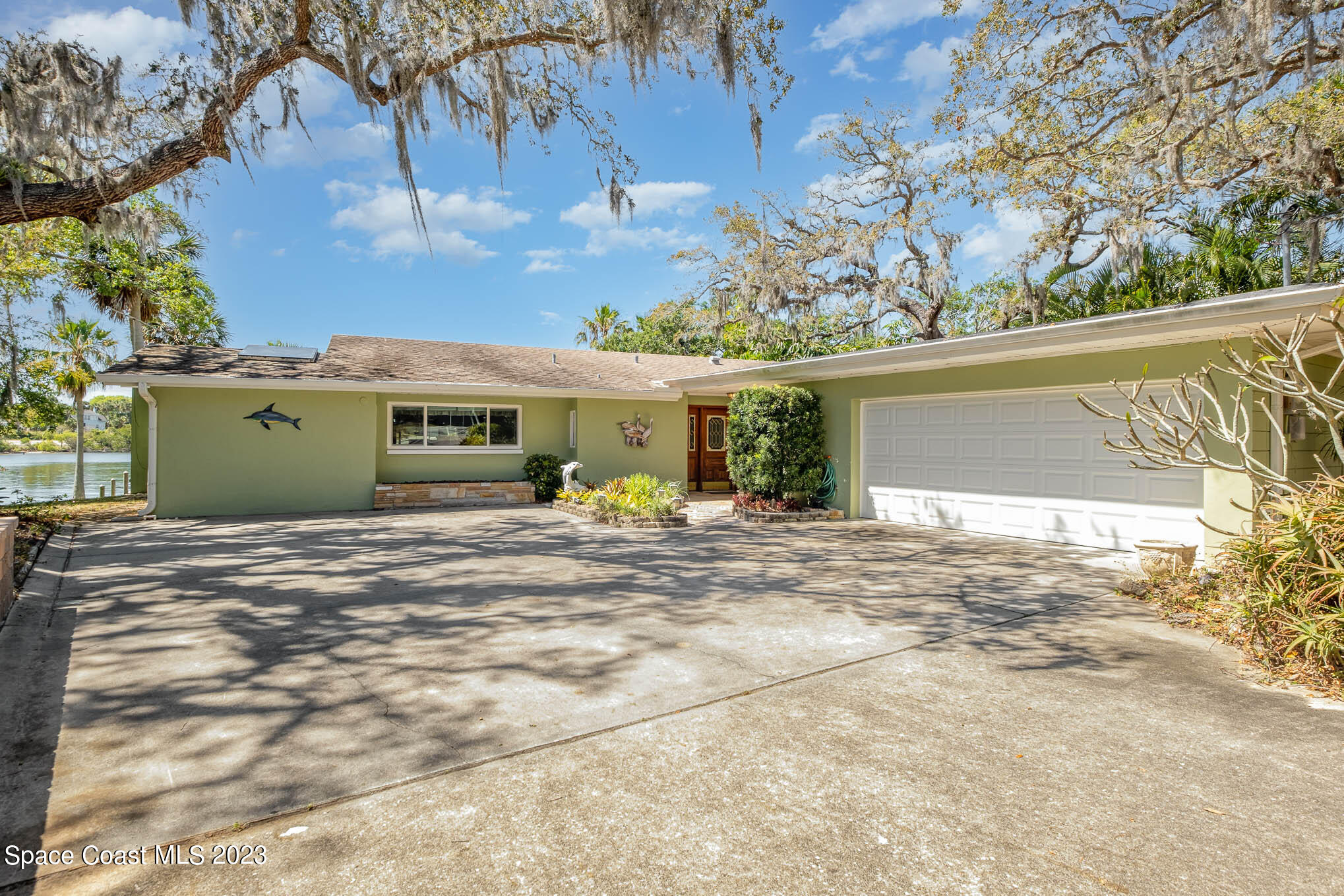 1466 Herndon Circle Palm Bay, FL 32905 - Photo 2 of 23 a view of a house with a yard and garage