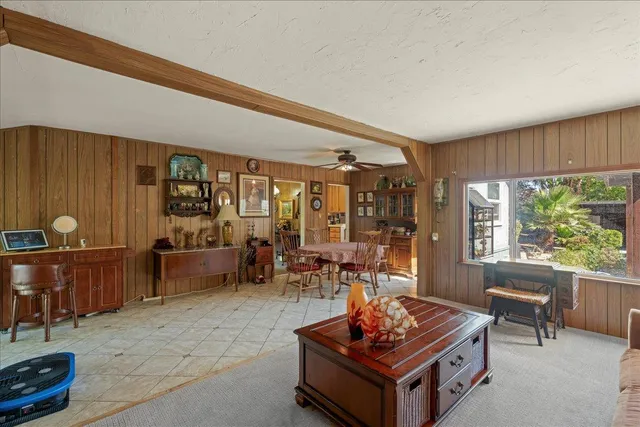 a living room with furniture a table and a large window