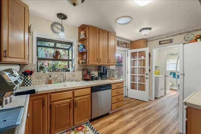 a kitchen with stainless steel appliances wooden floors and wooden cabinets