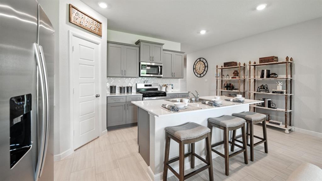 557 Pendleton Avenue Keene, TX 76059 - Photo 30 of 32 a kitchen with kitchen island a stove a table and chairs