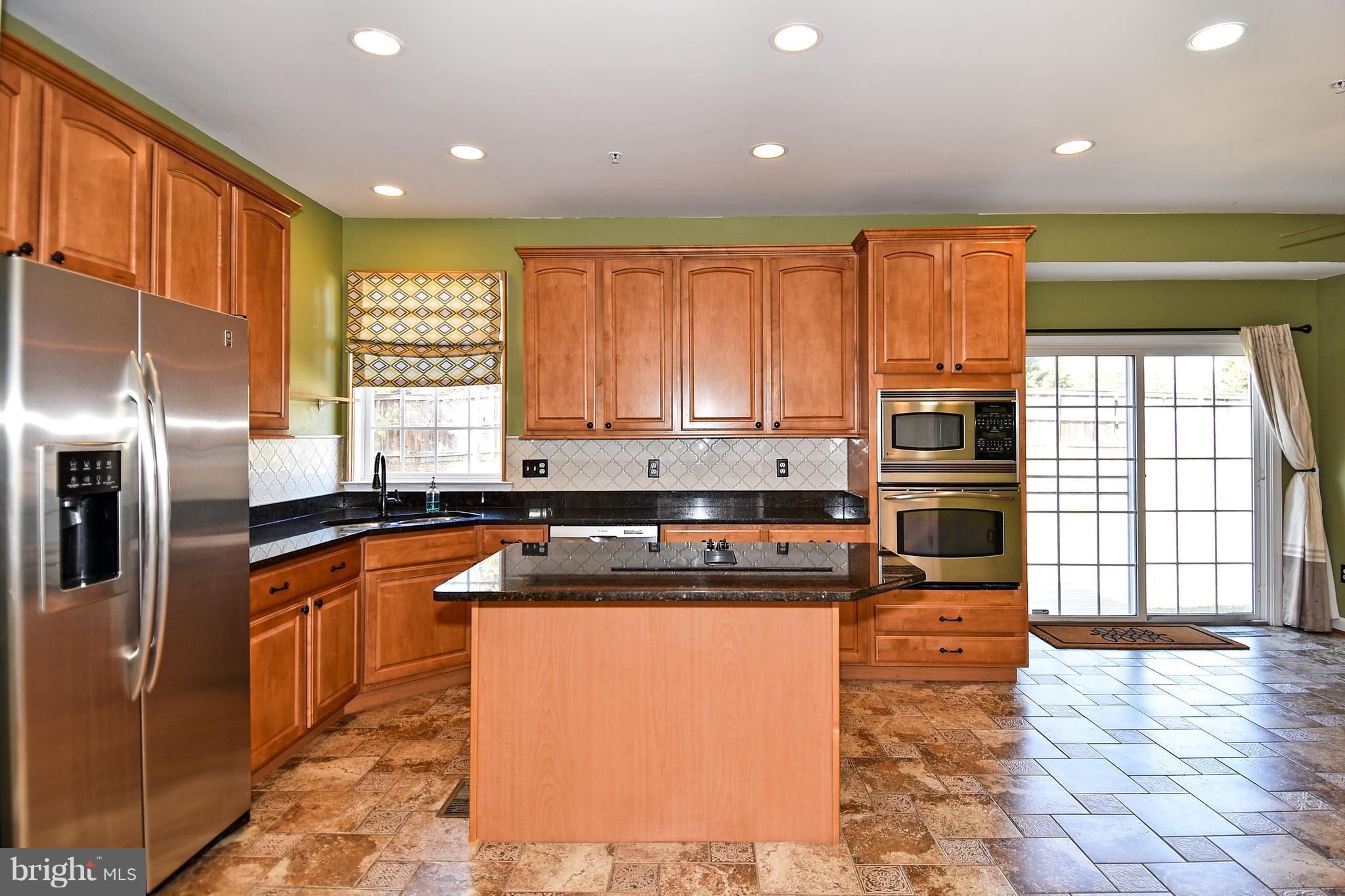14102 Punch Street Silver Spring, MD 20906 - Photo 7 of 30 a kitchen with stainless steel appliances granite countertop a stove a sink and a refrigerator