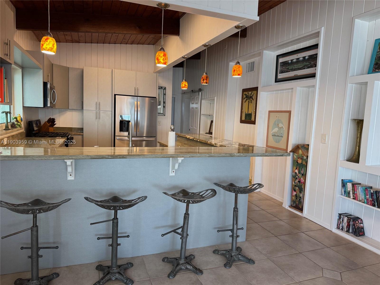 900 Morris Avenue Key Largo, FL 33037 - Photo 3 of 13 a kitchen with stainless steel appliances kitchen island granite countertop a refrigerator and chairs