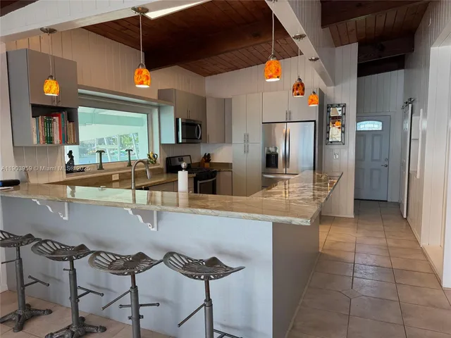a kitchen with stainless steel appliances granite countertop a sink and a refrigerator