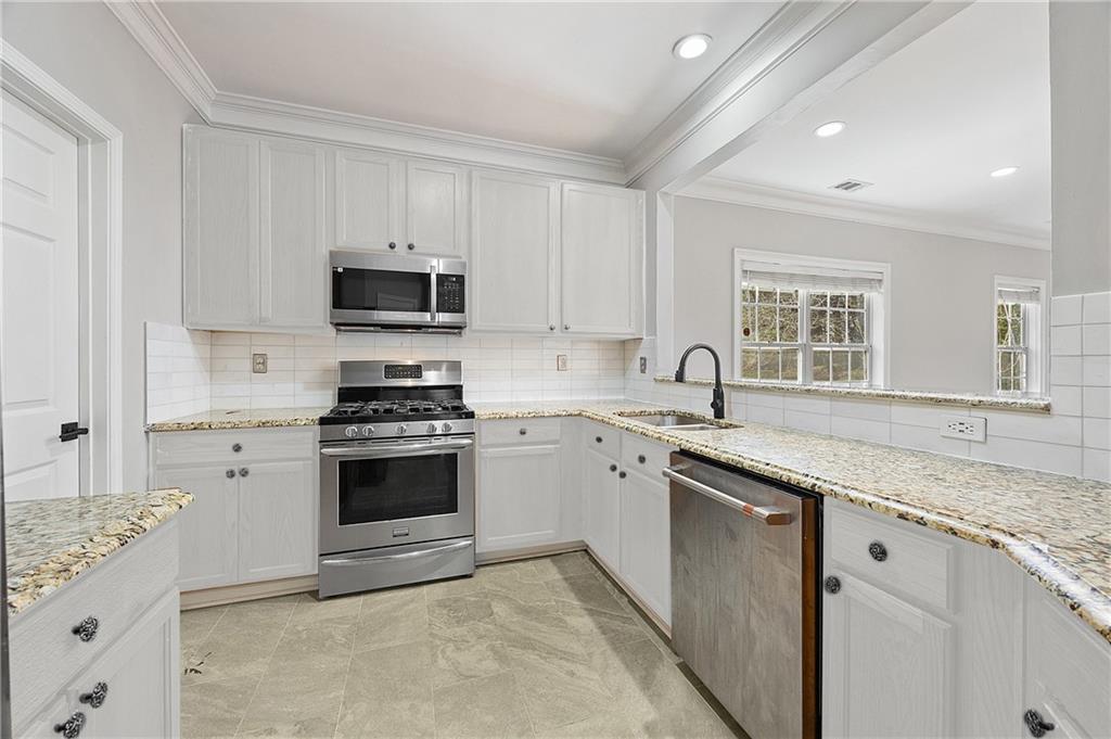 1644 Donovan's Ridge Kennesaw, GA 30152 - Photo 15 of 37 a kitchen with granite countertop a stove sink and microwave