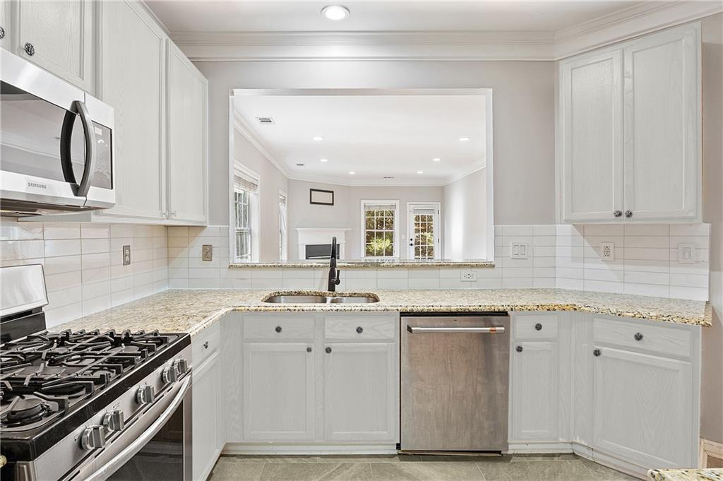 1644 Donovan's Ridge Kennesaw, GA 30152 - Photo 17 of 37 a kitchen with granite countertop a stove sink and cabinets