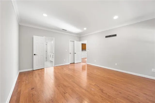 a view of an empty room with wooden floor