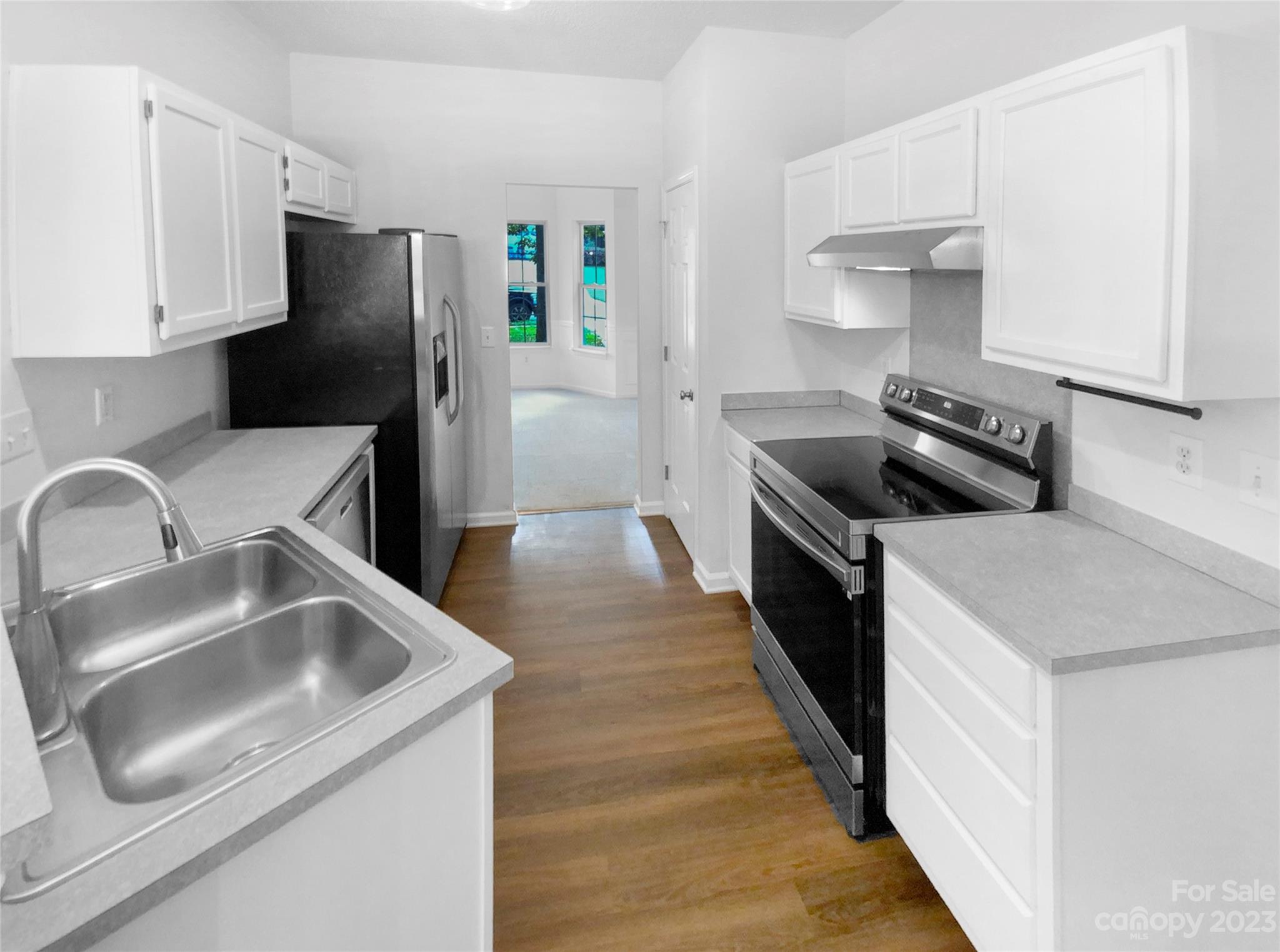 114 Shade Tree Circle Fort Mill, SC 29715 - Photo 12 of 20 a kitchen with stainless steel appliances a sink a stove and a refrigerator with wooden floor