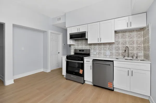 a kitchen with granite countertop white cabinets and white appliances