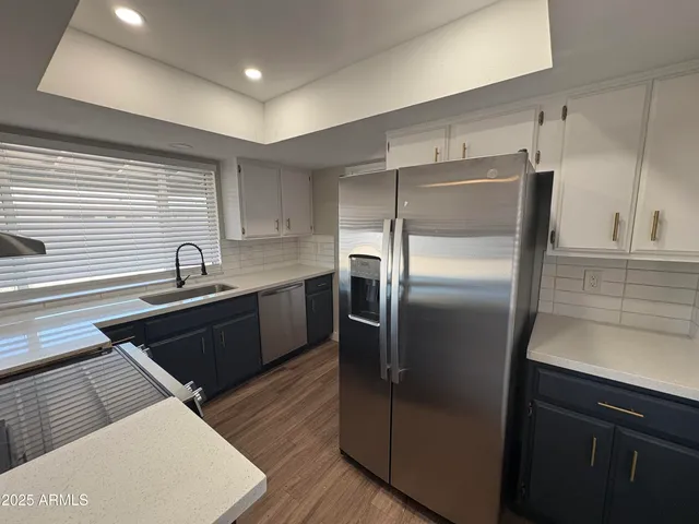 a kitchen with stainless steel appliances granite countertop a refrigerator and a sink