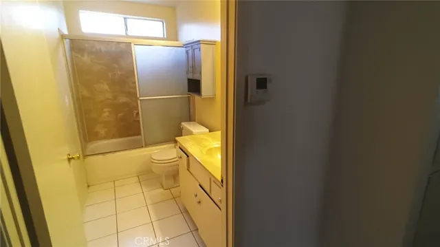 a bathroom with a granite countertop toilet and a shower