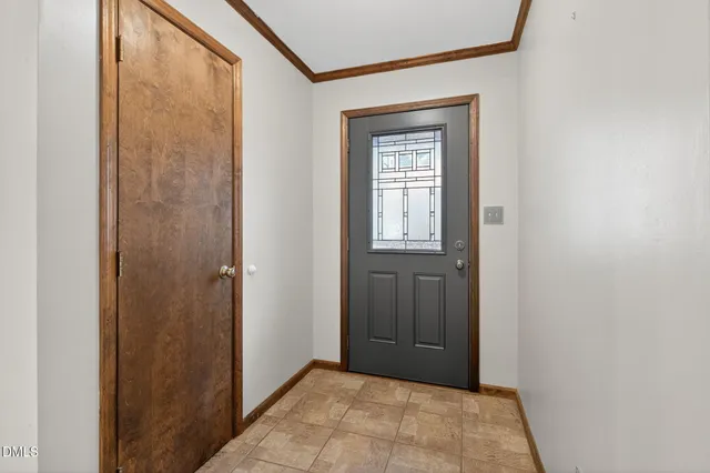a view of an empty room with a fireplace and a window