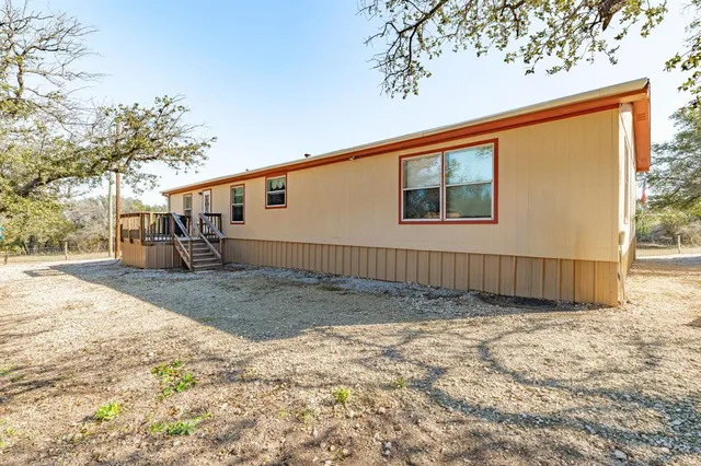 a backyard of a house with a barn table and chairs