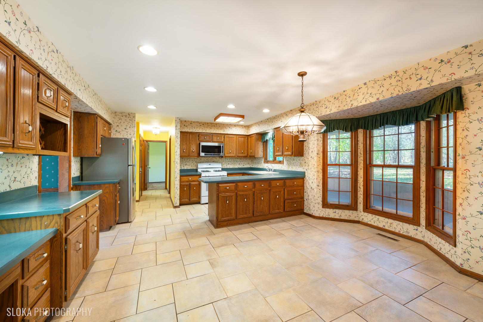 6906 Red Barn Road Crystal Lake, IL 60012 - Photo 10 of 40 a large kitchen with stainless steel appliances kitchen island granite countertop a sink and cabinets
