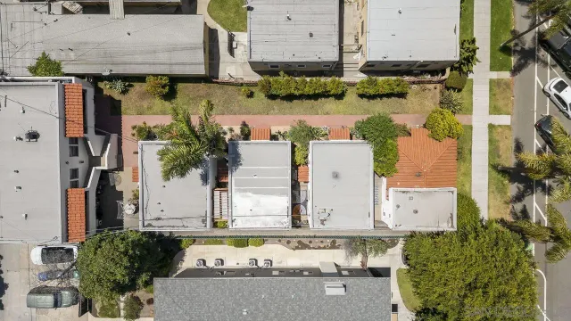 an aerial view of a residential houses with outdoor space and parking