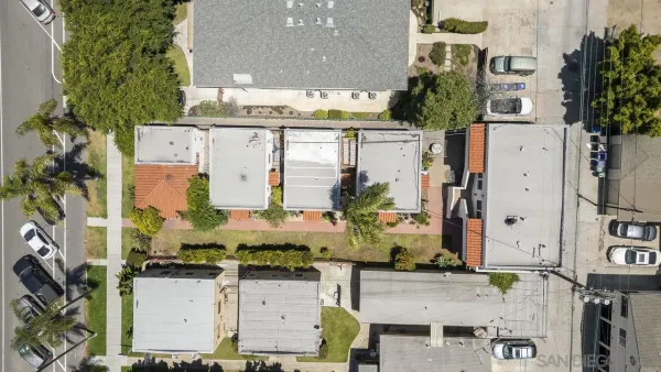 an aerial view of residential houses with outdoor space and parking