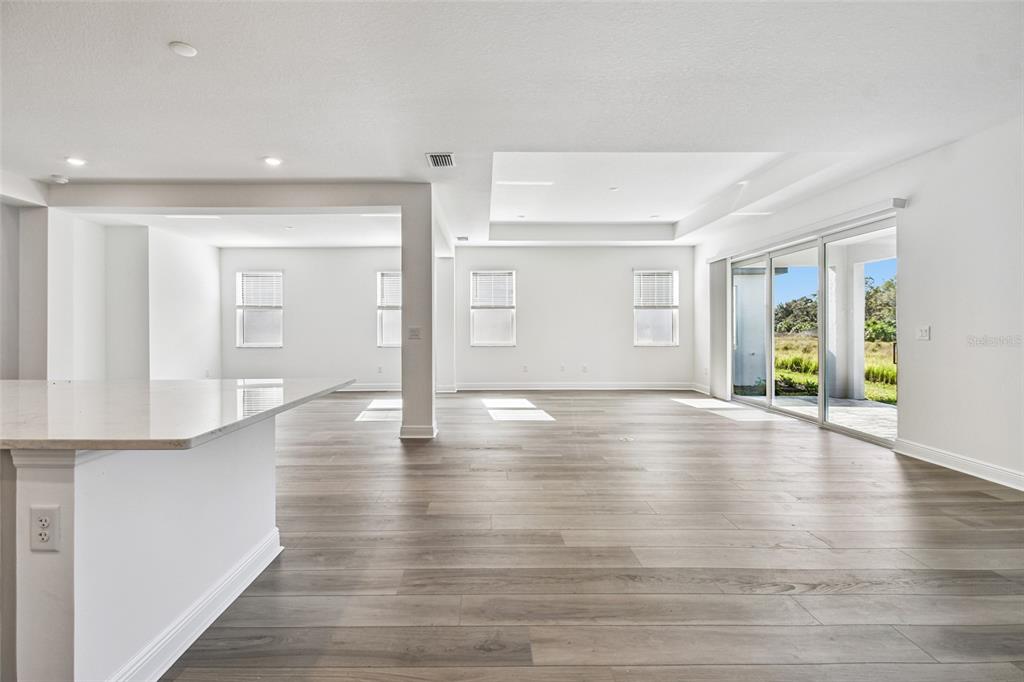 3677 142nd Terrace Parrish, FL 34219 - Photo 15 of 93 a view of an empty room with wooden floor and a window