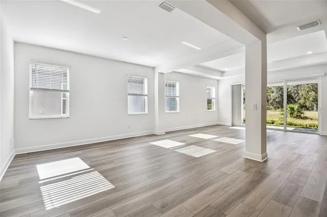 a view of a hallway with wooden floor and entryway