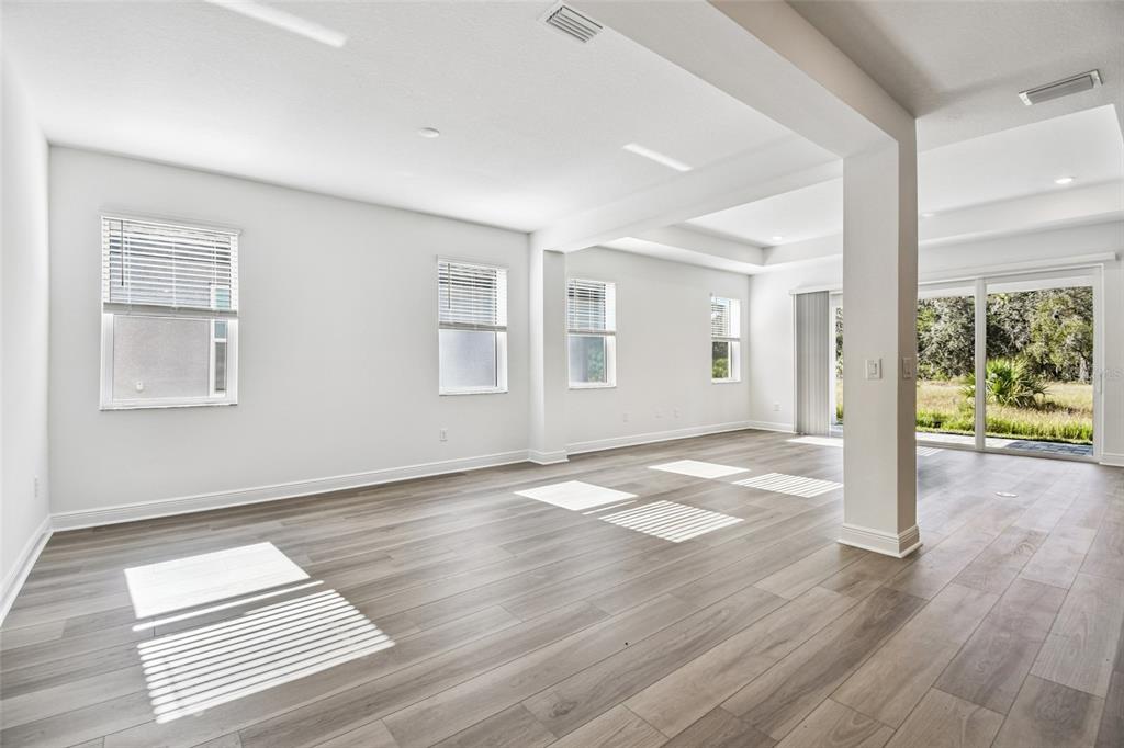 3677 142nd Terrace Parrish, FL 34219 - Photo 18 of 93 a view of an empty room with wooden floor and a window