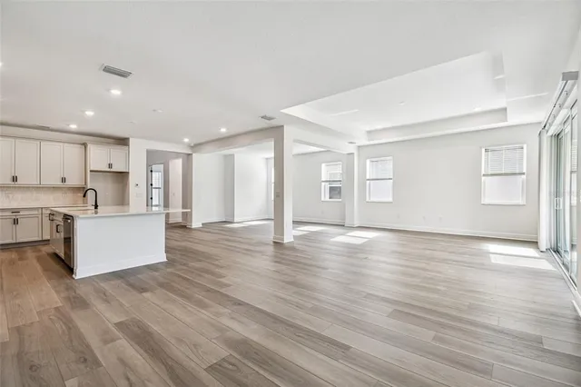 a view of kitchen with kitchen island wooden floors and stainless steel appliances