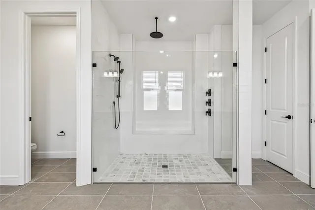 a bathroom with a sink a toilet a mirror and shower