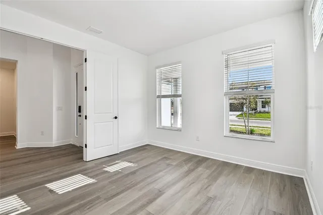 a view of a hallway with wooden floor and entryway