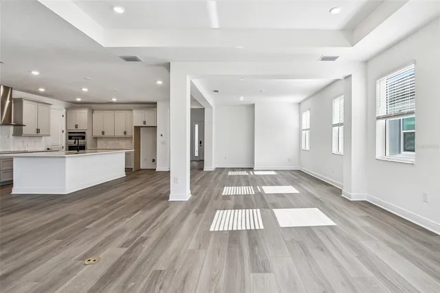 a view of a kitchen with wooden floor and electronic appliances