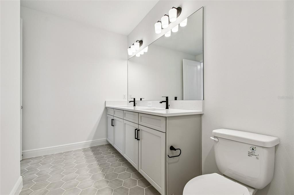 3677 142nd Terrace Parrish, FL 34219 - Photo 55 of 93 a bathroom with a toilet sink and mirror