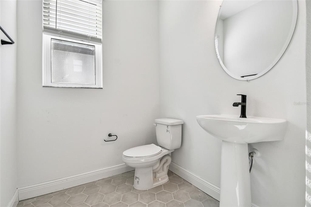 3677 142nd Terrace Parrish, FL 34219 - Photo 72 of 93 a bathroom with a toilet sink and mirror