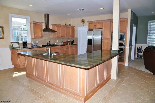 a living room with furniture a table and kitchen view