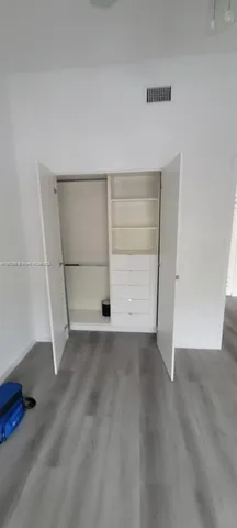 an empty room with a wooden floor and more cabinets