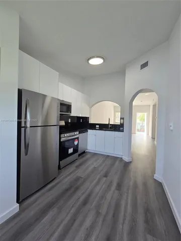 a kitchen with a refrigerator and a stove top oven