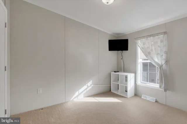 an empty room with windows and cabinet