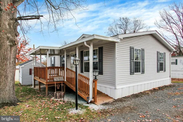 a view of a house with a yard and wooden deck
