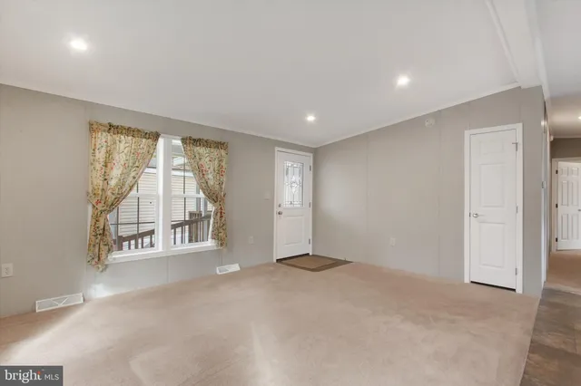 an empty room with a fireplace and windows