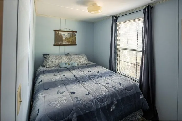 a bedroom with a bed and a window