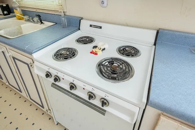 a kitchen with a stove and white cabinet