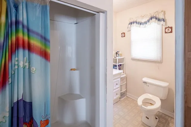 a bathroom with a toilet and a shower curtain