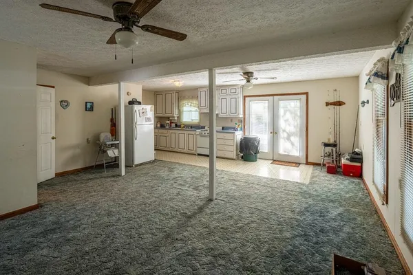 a view of a livingroom with a flat screen tv wooden floor and windows